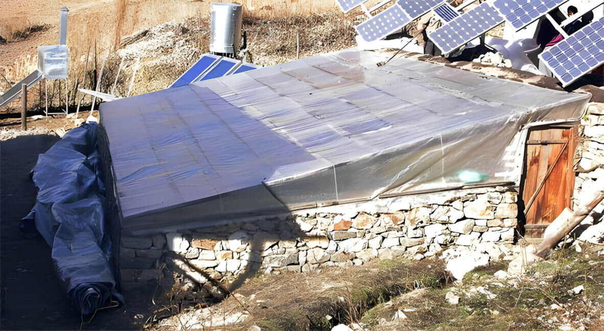 Greenhouse in Nepal built with stone walls, wood beams, and UV plastic for insulation