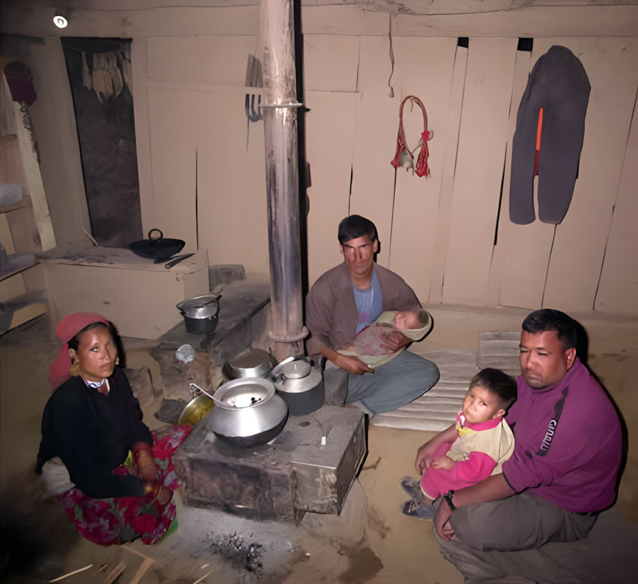 Families sitting around a smokeless metal stove in Humla, preparing meals to improve nutrition and food security.