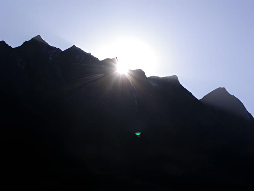 Rays of sunlight breaking through shadows, symbolizing hope and growth.